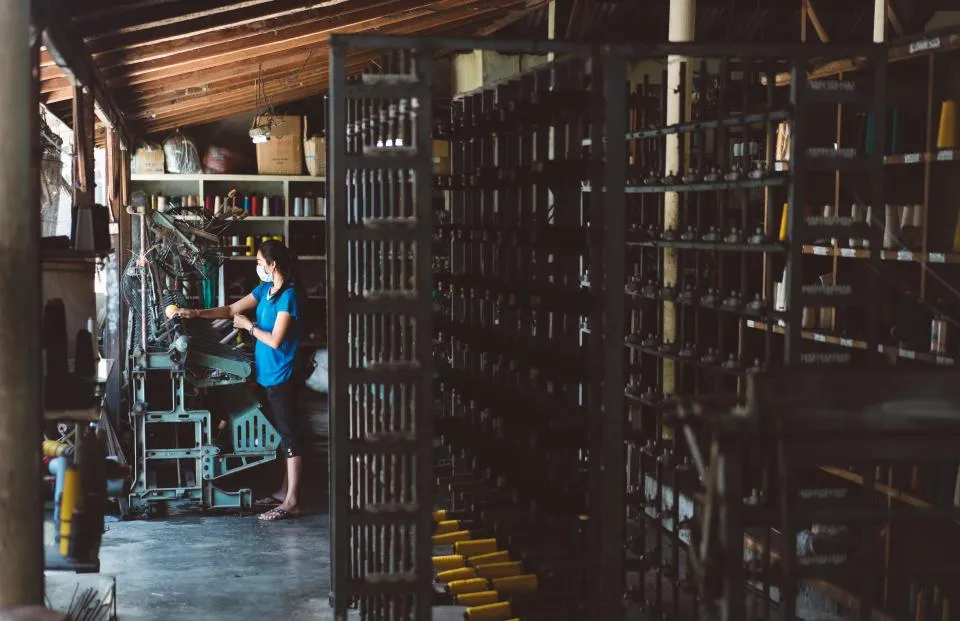 Worker on a factory floor among production racks