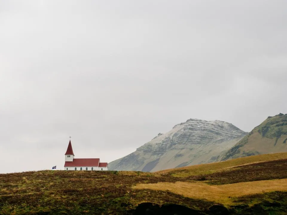 Small church on open land below the hills