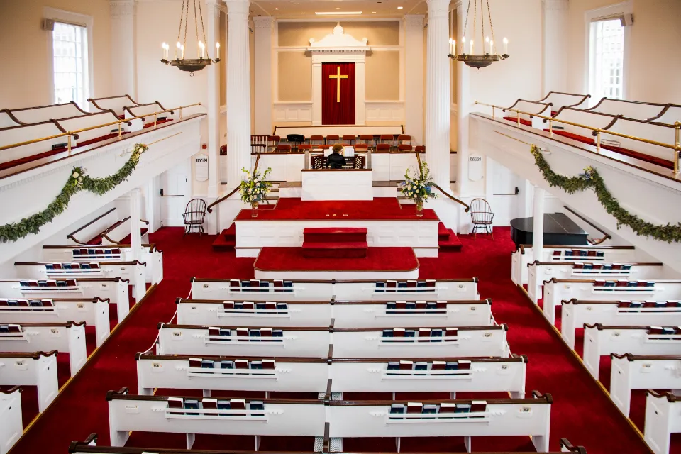 Church sanctuary with rows of white pews